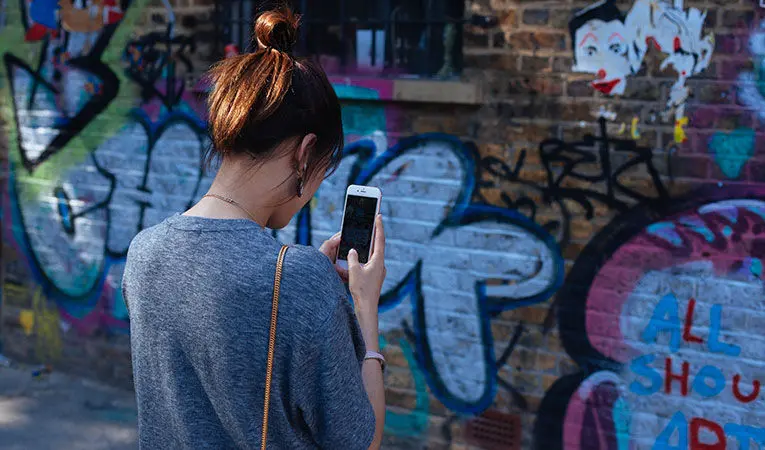 woman taking photo of graffiti