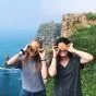 Two girls standing on edge of a cliff with yellow flowers on eyes 