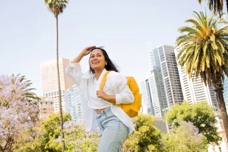 woman with sunglasses and backpack walking 